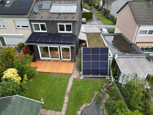 Solaranlage auf Dach eines Privathauses mit speziell angefertigter Aufständerung für weitere Module im Garten