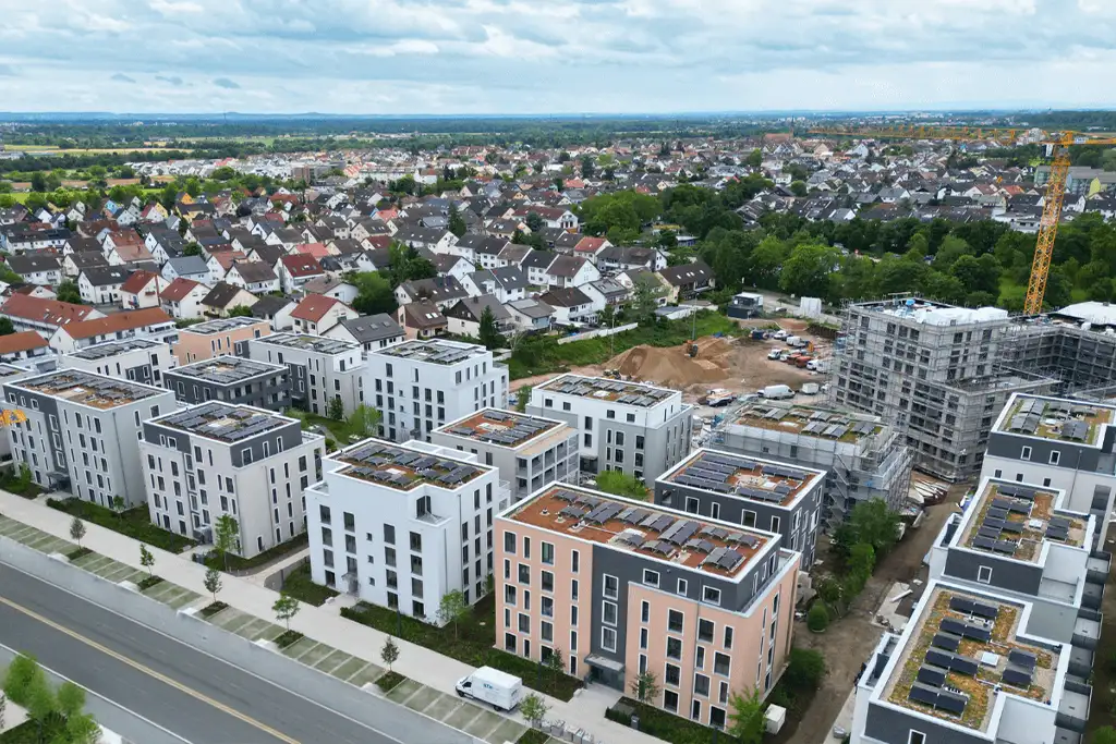 Modernes Mehrfamilienhäuser mit Photovoltaik-Anlage auf dem Dach zur gemeinschaftlichen Gebäudeversorgung.